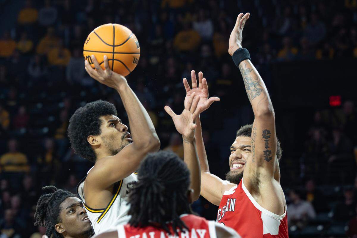 Wichita State’s Harlond Beverly shoots against Western Kentucky’s Rodney Howard during the second half of their game at Koch Arena on Thursday night. 