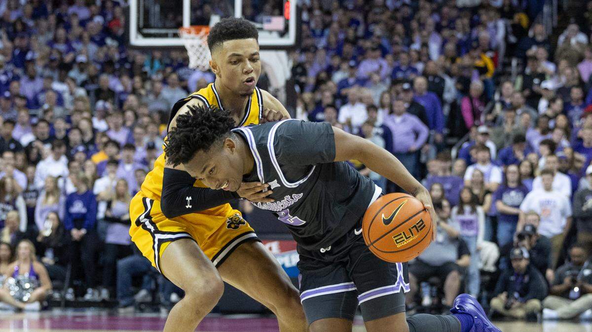 Kansas State’s Tylor Perry is fouled by Wichita State’s Xavier Bell during the first half of Kansas State’s 69-60 win over the Shockers on Thursday night at the T-Mobile Center in Kansas City.