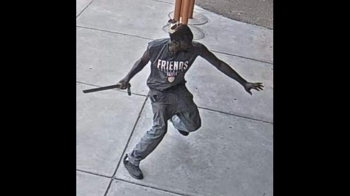 A man wielding what police believe is a long machete rears back to hit a person on Tuesday in the 700 block of West Second. Wichita police are asking for help finding the man in the photo.