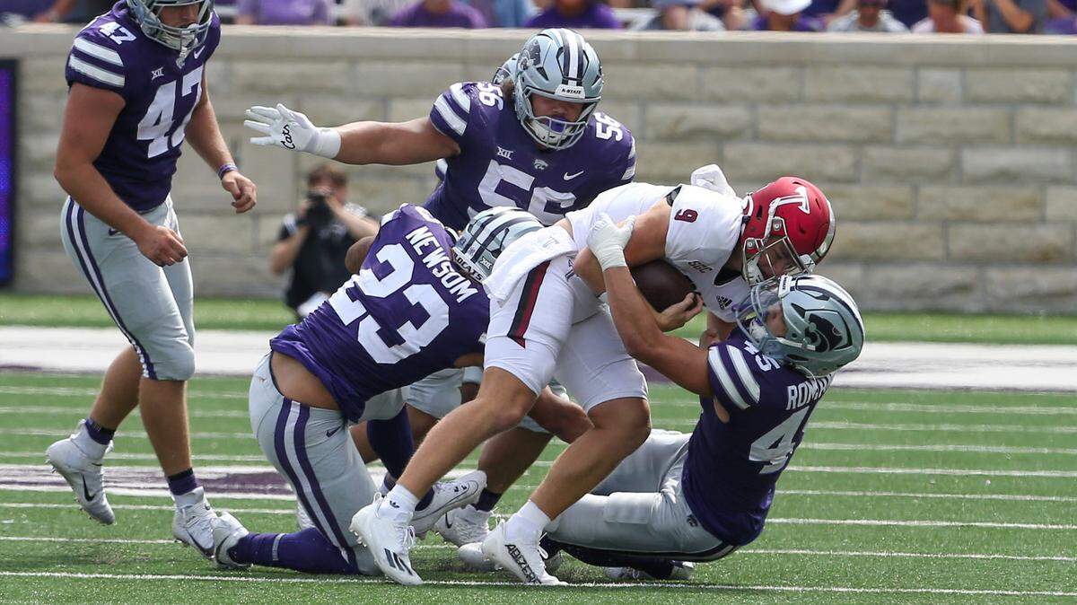 Troy Trojans quarterback Goose Crowder (9) is tackled by Kansas State Wildcats linebacker Austin Romaine (45), defensive tackle Damian Ilalio (56) and linebacker Asa Newsom (23) during the fourth quarter at Bill Snyder Family Football Stadium.
