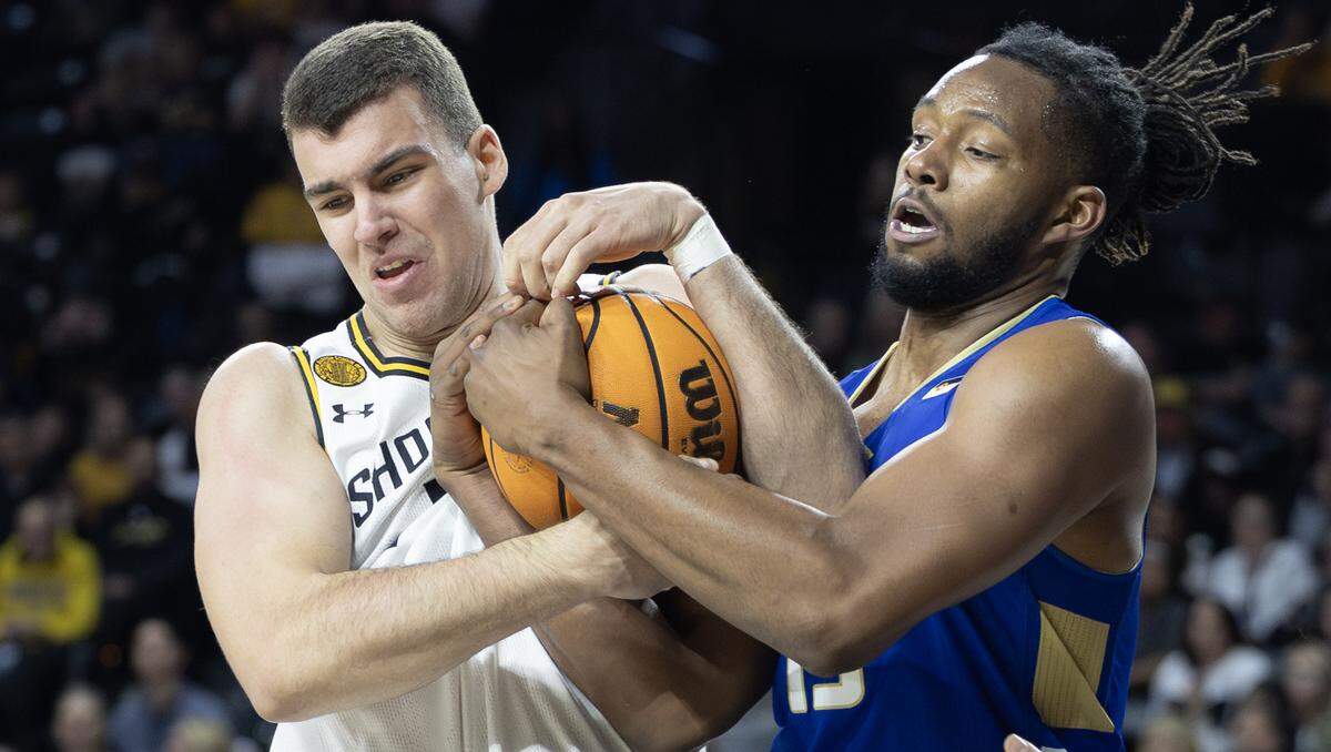 Wichita State’s Matej Bosnjak gets tangled up with Tulsa’s Jared Garcia while fighting for a rebound on Sunday at Koch Arena. 