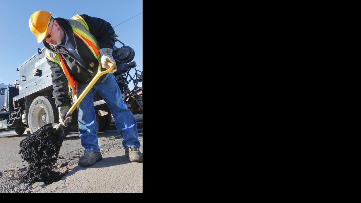 City of Wichita street maintenance worker David Palmitier fixes potholes on 27th Street South between McLean and Seneca on Tuesday. (Jan. 21, 2014)


