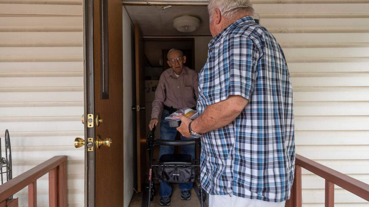 Tom Shockey, a volunteer driver for Meals on Wheels, delivers a pre-packaged meal to a Alva Kite on Wednesday. The Meals on Wheels programs is feeling the pinch of higher gas prices.