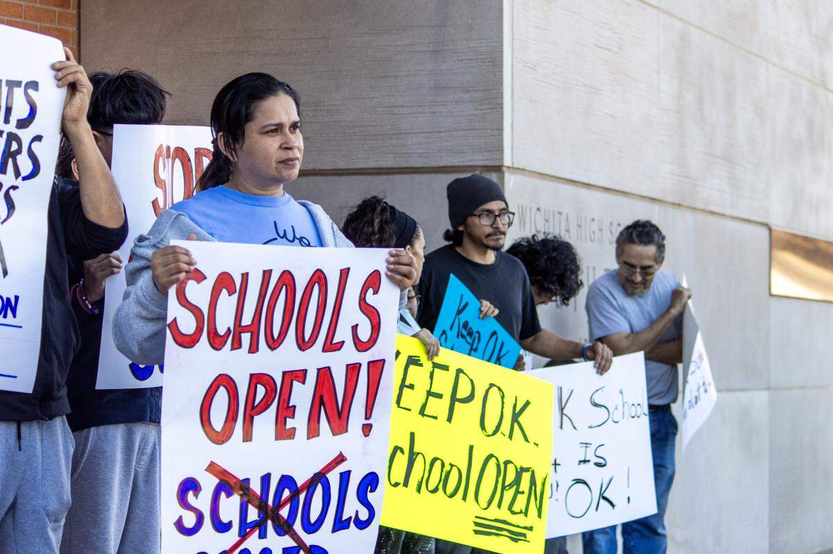 A dozen or so parents and community members protested ahead of the Wichita School Board vote on the timeline to close four elementary schools.