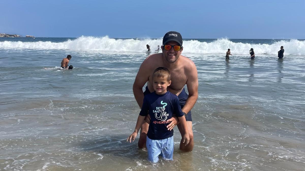 Jon Rolph and his youngest child, Bear, enjoyed playing in the ocean recently. Rolph, who has spent two years overcoming cancer, was released from physical restrictions on June 1 and has been making up for lost active time.