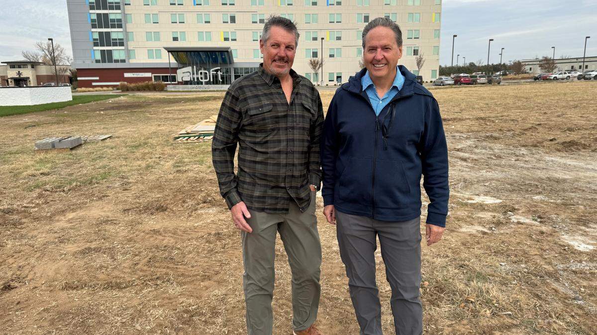 Marque Peer, vice president of development for Great Plains Ventures, stands on the future sit of TapNPaddles with owner Mike Ventling. The facility, which will feature a restaurant and bar and 12 indoor pickleball courts, will go up on the field in front of the Aloft hotel at K-96 and Oliver.