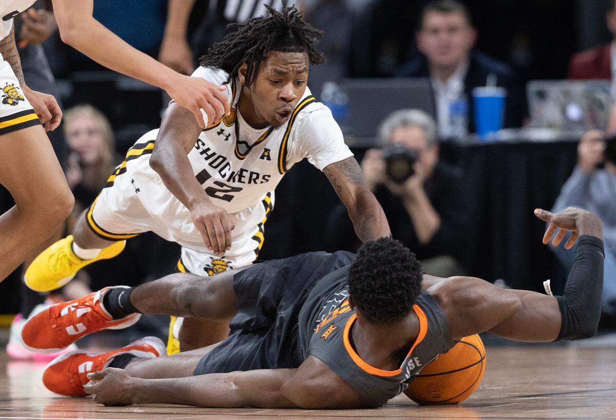 Wichita State’s Melvion Flanagan dives for a loose ball against Oklahoma State’s Moussa Cisse during the second half of their game at Intrust Bank Arena on Saturday night.