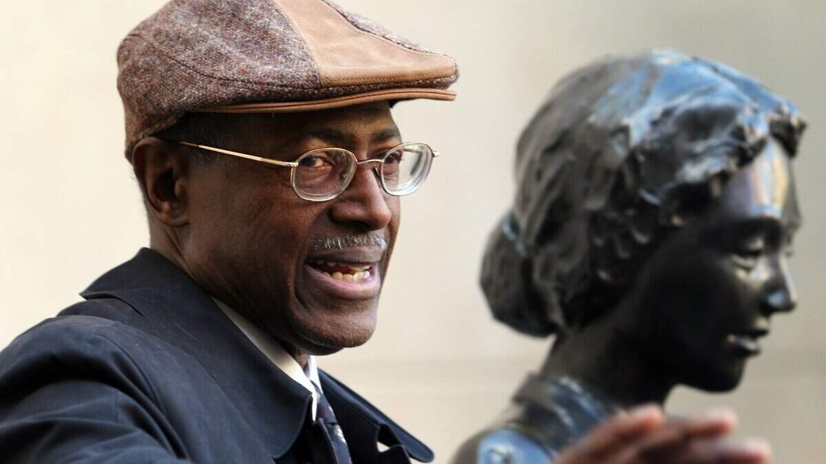 In this file photo from 2006, Ron Walters stands at the statue depicting the Dockum drug store counter. Walters was the president of the youth chapter of the Wichita branch NAACP during the time of the sit-in. (Jaime Oppenheimer/The Wichita Eagle)