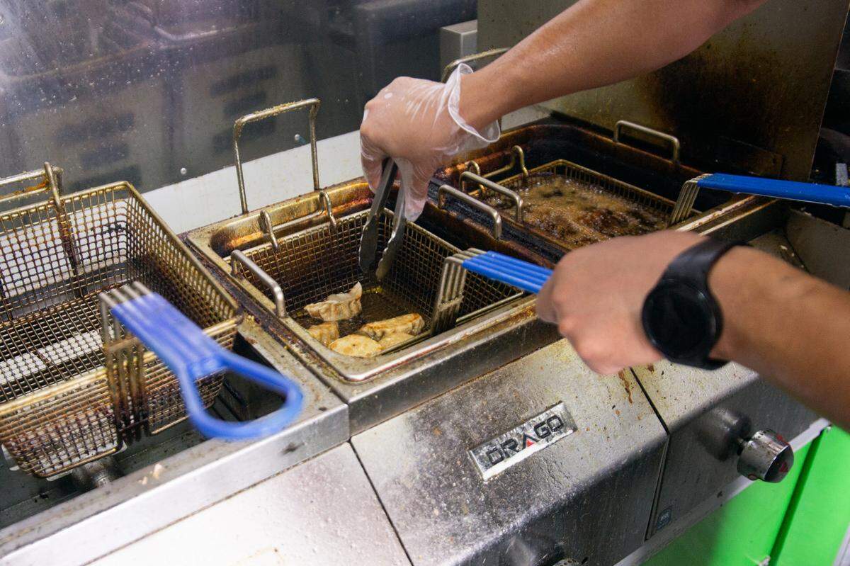 Unnat Ghimire fries up momos for customers outside of the Sky Lounge at a local beer pop-up. Ghimire, owner of The Momo Stop, takes his food truck to different parts of the city for events.
