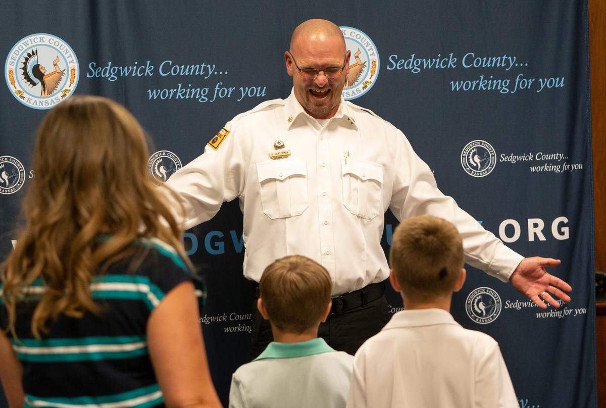 Kevin Lanterman reaches out his arms for hugs from his sons Branson and Boston after he was named director of emergency medical services for Sedgwick County. (June 16, 2022)