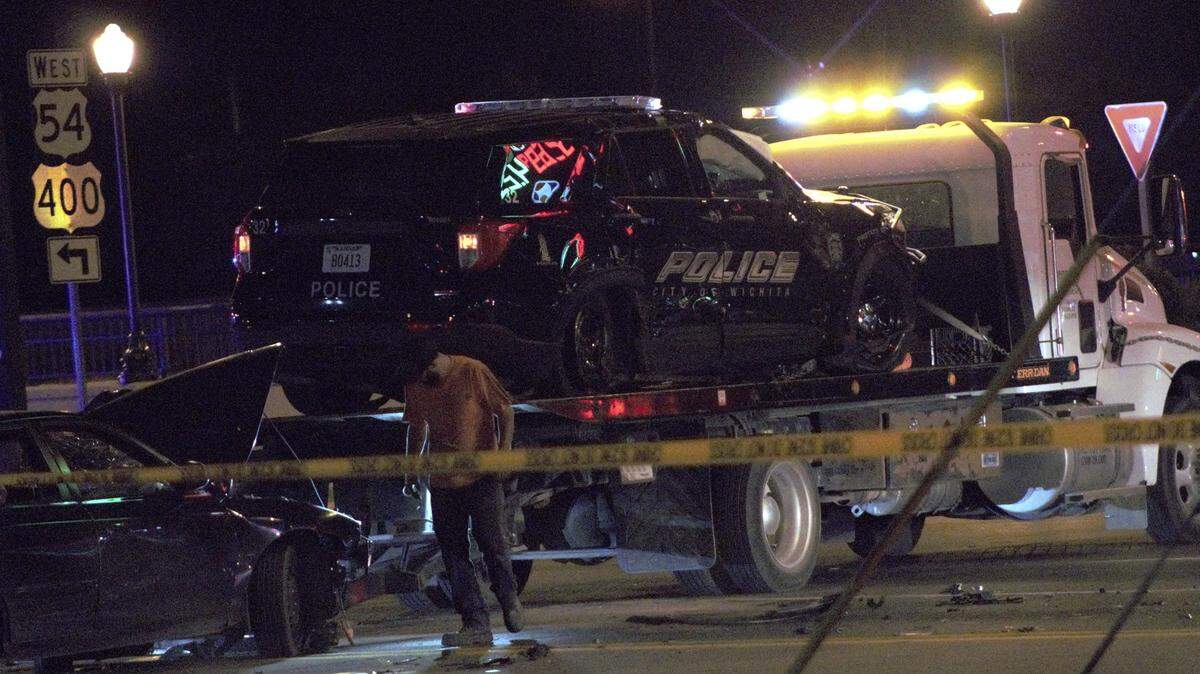 A tow truck loads up a Wichita Police Department cruiser after a three car wreck that sent four people to the hospital Sunday night in east Wichita.