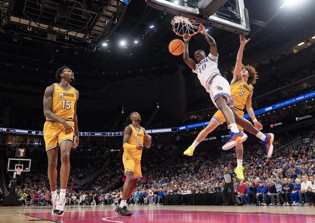 Kansas’ Flory Bidunga throws down an alley-oop dunk over Missouri’s T.O. Barrett during the second half of their game at T-Mobile Center on Sunday, Dec. 7, 2025.