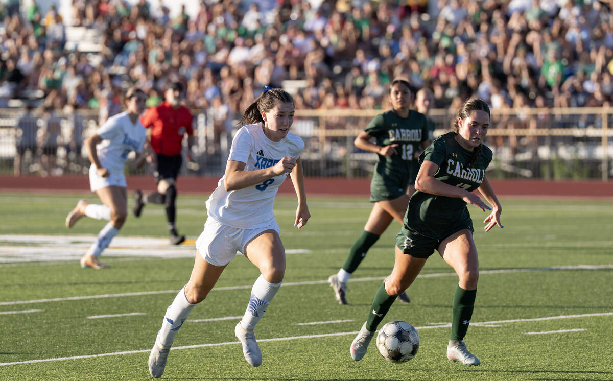 Kapaun Mt. Carmel’s Sara Claire Michaelis, left, and Bishop Carroll’s Rachel Hawkins, right, fight for the ball in a Class 5A quarterfinal game that the Crusaders won 5-3.