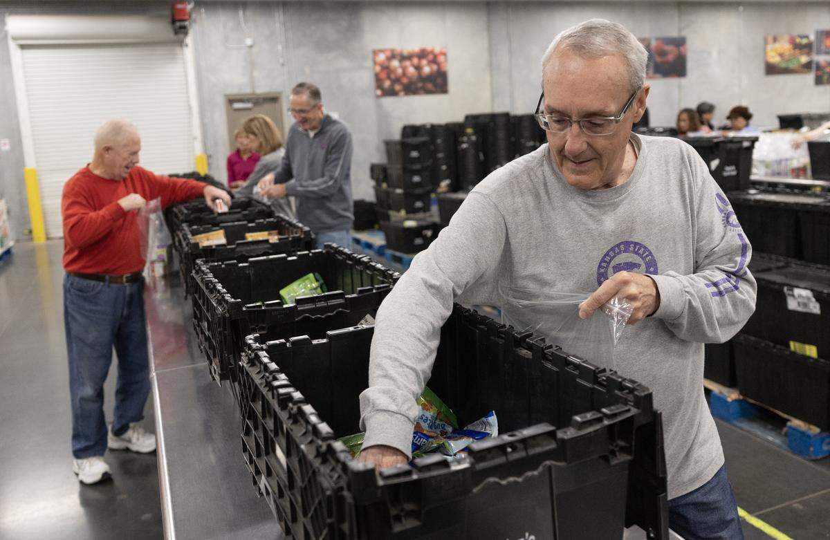 Monte Shaw, along with other volunteers at the Kansas Food Bank Warehouse, load bags of food for shipment at the facility Tuesday, Oct. 28, 2025. The food bank is hoping to get additional community support over worry about what effect the pause in SNAP benefits might have on hungry Kansans.
