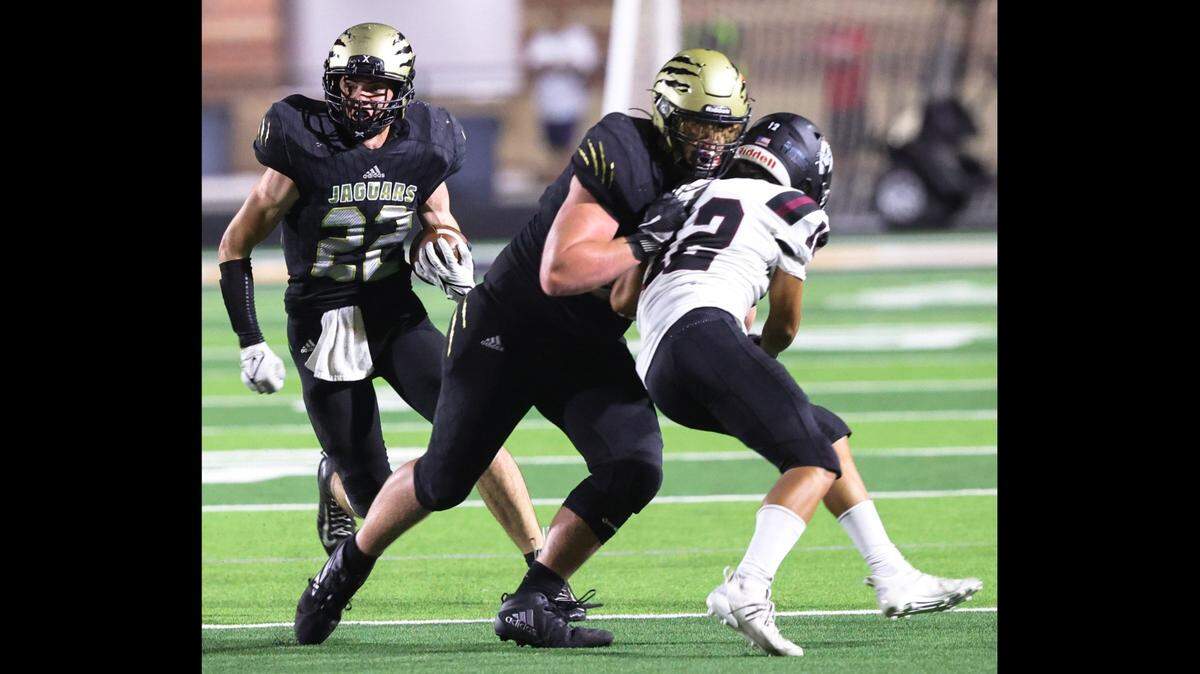 Andover Central offensive lineman Drew Daniels (right) helps spring running back Ashton Barkdull for the game-winning touchdown in the fourth quarter of the Jaguars’ 21-19 win over Buhler on Friday night.
