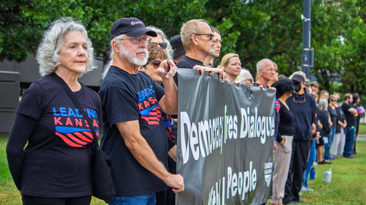 Members of Leading Kansas stand in silent solidarity while protesting U.S. Rep. Ron Estes. Estes visited Wichita on Aug. 28 to provide an update on federal issues during a forum hosted by the Wichita Regional Chamber of Commerce.