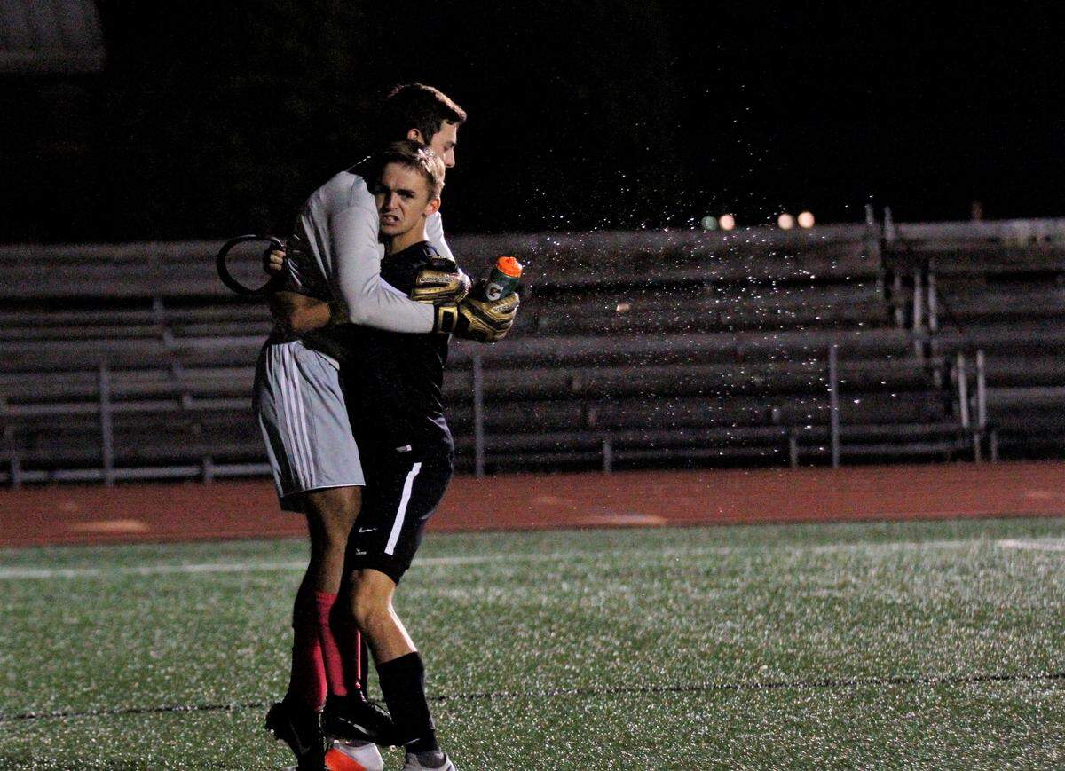 Andover Central seniors Max Wurth and Davis Joseph celebrate the Jaguars’ 1-0 win over Campus on Tuesday as Davis sprays his water bottle. (Sept. 11, 2018)