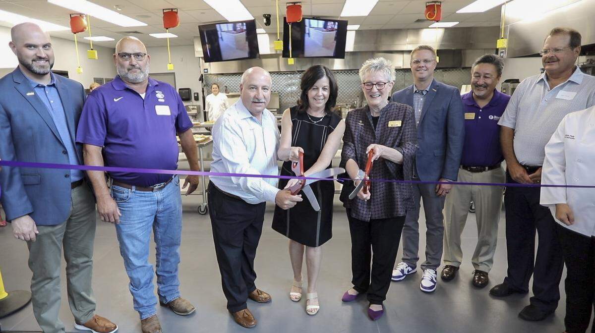 Scott and Betsy Redler, middle, are pictured in 2022 cutting a ceremonial ribbon at the opening of the Redler Institute of Culinary Arts in Andover.