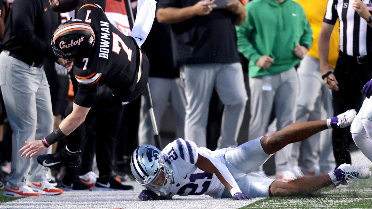 Oklahoma State’s Alan Bowman (7) is knocked out of bounds by Kansas State’s Marques Sigle (21) in the first half of the college football game between the Oklahoma State University Cowboys and the Kansas State Wildcats at Boone Pickens Stadium in Stillwater.