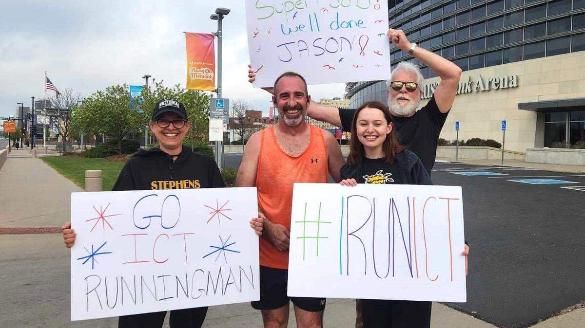 Jason Niblack, center, became the first person to finish running every street in Wichita with a run that ended Easter morning at Intrust Bank Arena. His wife, daughter and longtime friend were waiting for him. 