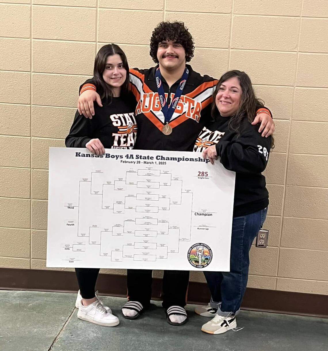 Augusta senior Willy Jon Morales is joined by his sister, Elly, and his mother, Ruth, after winning the state championship his father always wanted for him.