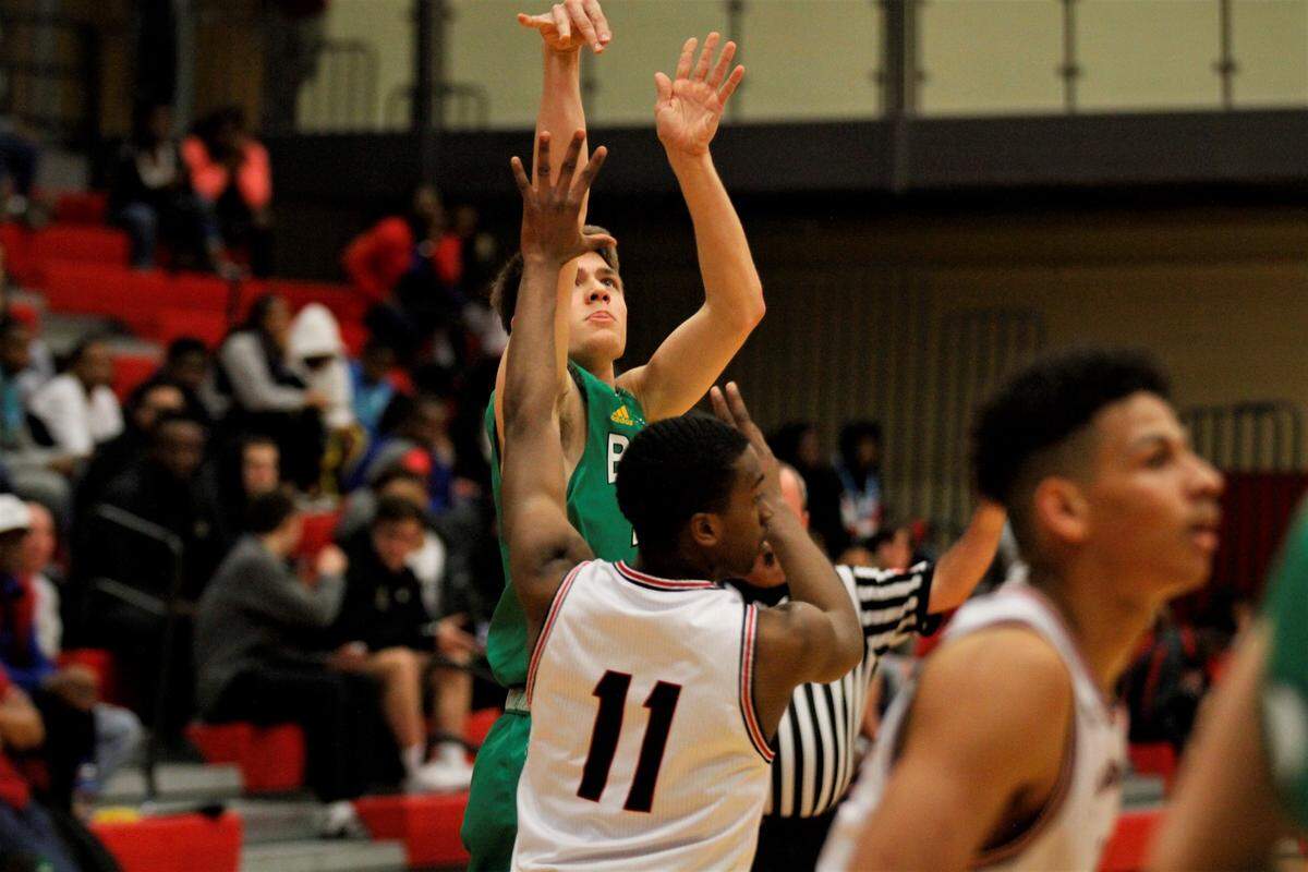 Bishop Carroll’s Carsen Pracht eyes up a three-pointer over Wichita Heights’ DJ Hudspeth during the Golden Eagles’ 61-46 win over the Falcons on Tuesday night. (Jan. 8, 2019)