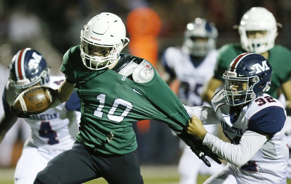 Derby’s Dax Benway tries to shake off Manhattan defender#32 BJ Young as he runs for a touchdown late in the first half Friday night in Derby. (November 16, 2018)