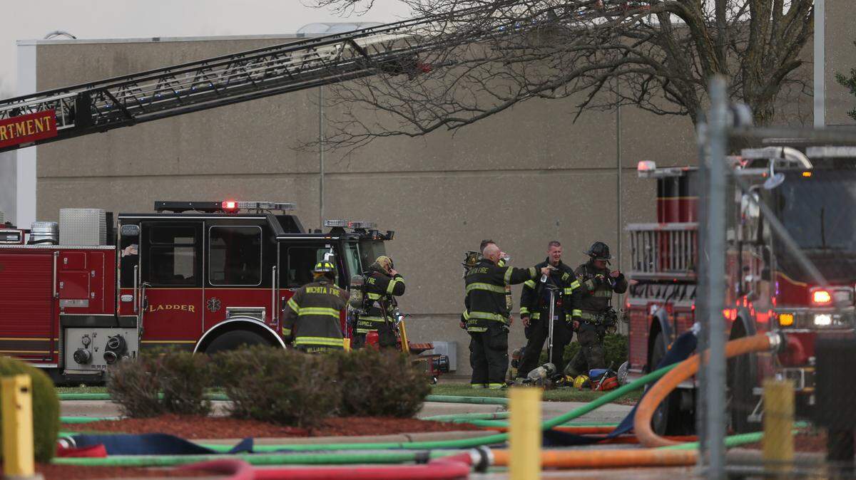 Firefighters clean up at the scene of a fire on the north side of the Coleman factory complex near 37th and Hydraulic Wednesday evening.