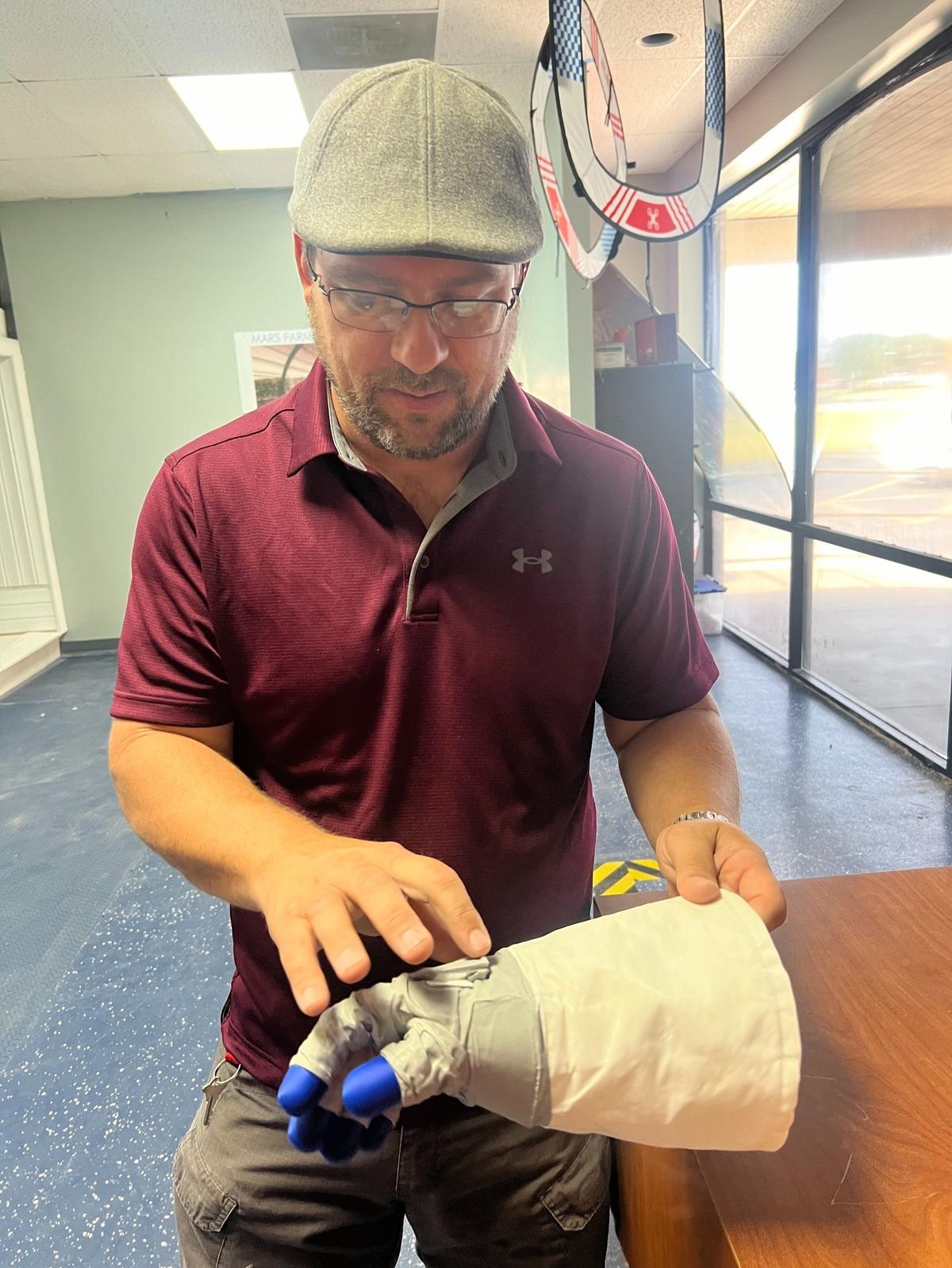 Travis Keyser demonstrates a 3D print of the exact specifications of astronaut Neil Armstrong’s hand from his mission to the moon. Printing is part of the experience at the new Space Discovery Institute in Andover.