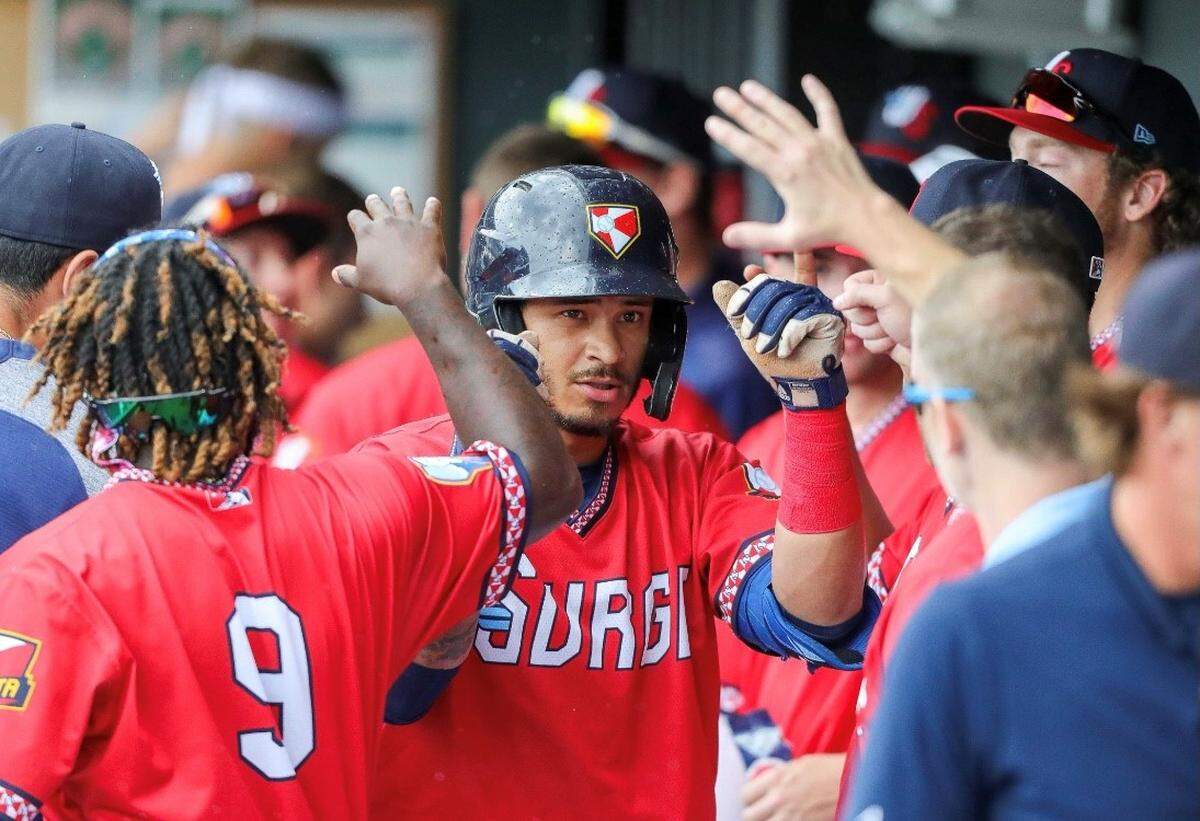 Wichita Wind Surge player Austin Martin is congratulated in the dugout following a home run.
