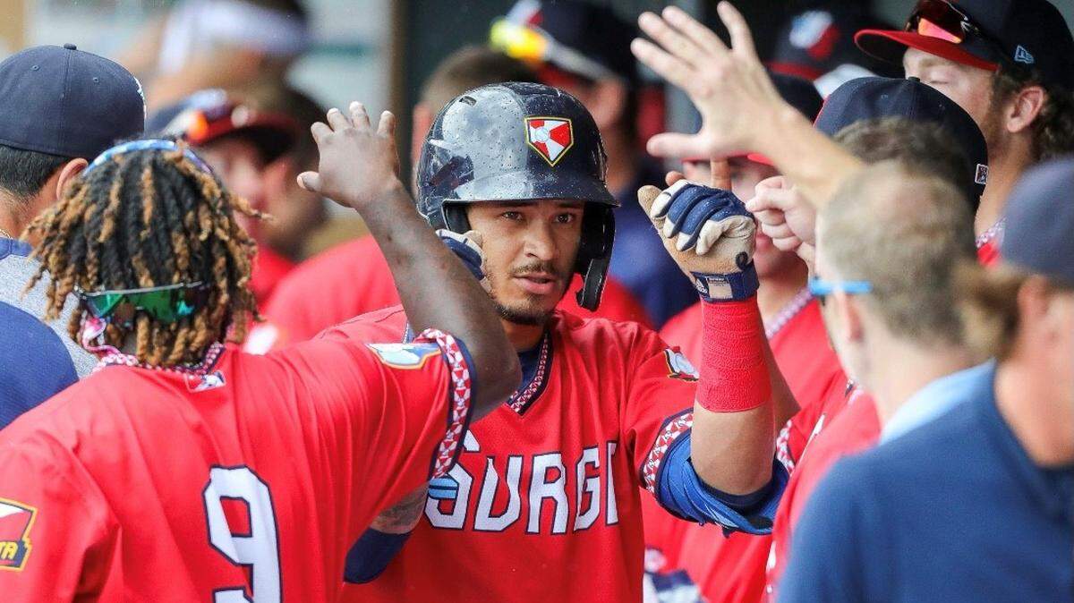 Wichita Wind Surge player Austin Martin is congratulated in the dugout following a home run.