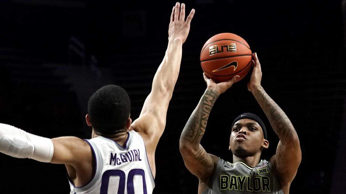 Baylor guard James Akinjo (11) shoots over Kansas State guard Mike McGuirl (00) during the first half of an NCAA college basketball game Wednesday, Feb. 9, 2022, in Manhattan, Kan. (AP Photo/Charlie Riedel)