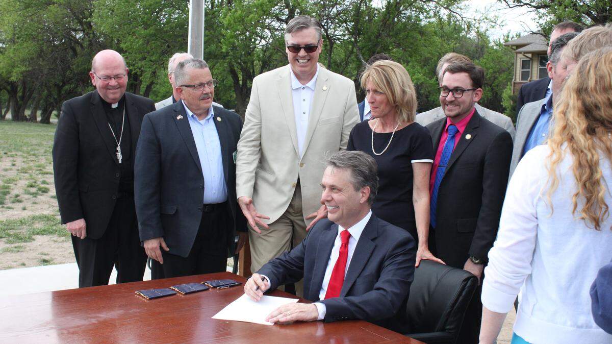 Kansas Gov. Jeff Colyer signs the Adoption Protection Act into law at the Youth Horizons Kinloch Price Boys Ranch in Valley Center.