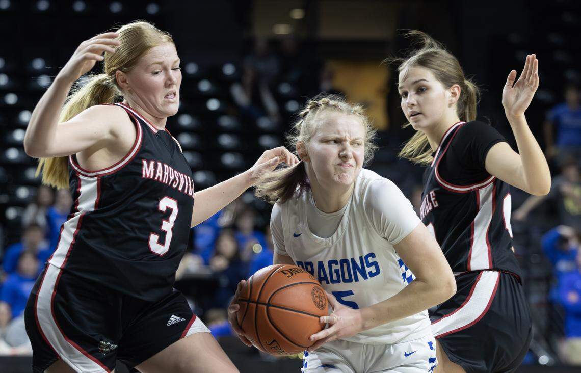 Halstead’s Piper Schroeder looks for a path to the basket between Maryville defenders Aubrey Dressman, left, and Hannah Whitesell during the second half of their class 3A quarter final game at Koch Arena on Wednesday.