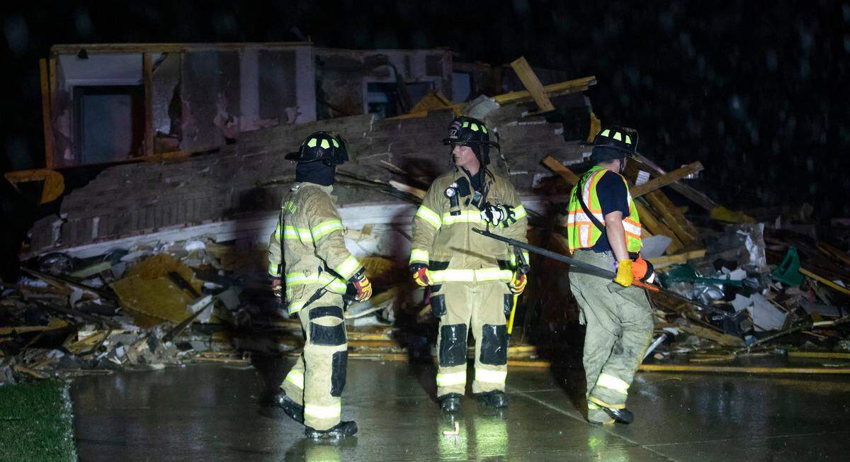 Firefighters search a home on south Hedgewood Street in Andover on Friday night after a tornado ripped through the area.