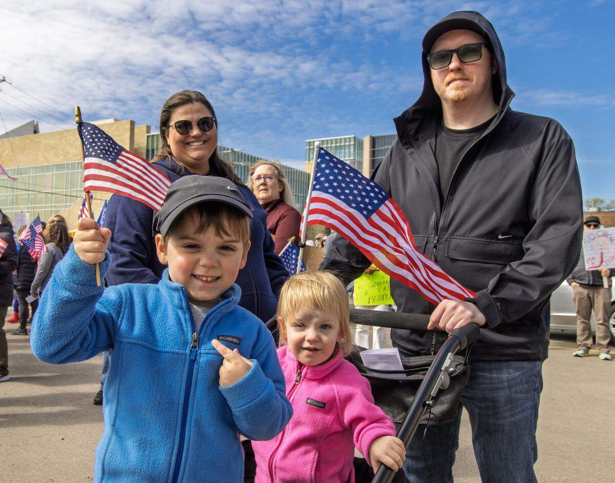 Catherine Wisdom, a volunteer coordinator with Leading Kansas, with her son, Levi, and daughter, Isla. She participated in the No Kings 3.0 protest Saturday, marching up Broadway to Douglas, where protesters rallied into the afternoon.