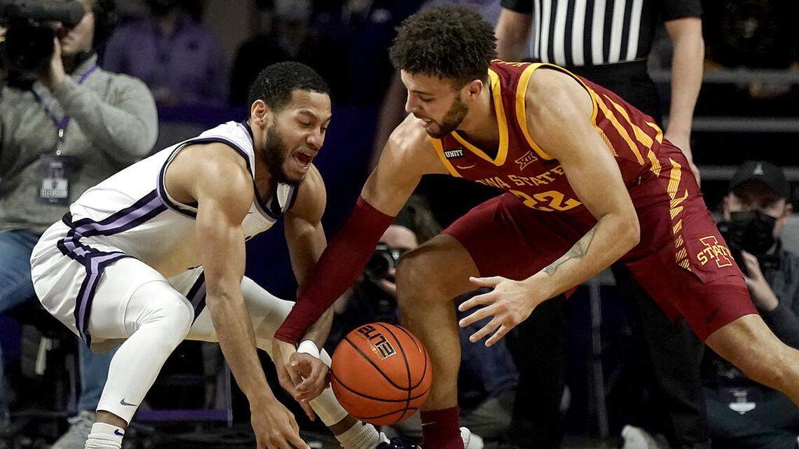 Kansas State guard Markquis Nowell, left, and Iowa State guard Gabe Kalscheur (22) chase a loose ball during the first half of an NCAA college basketball game Saturday, Feb. 26, 2022, in Manhattan, Kan. (AP Photo/Charlie Riedel)