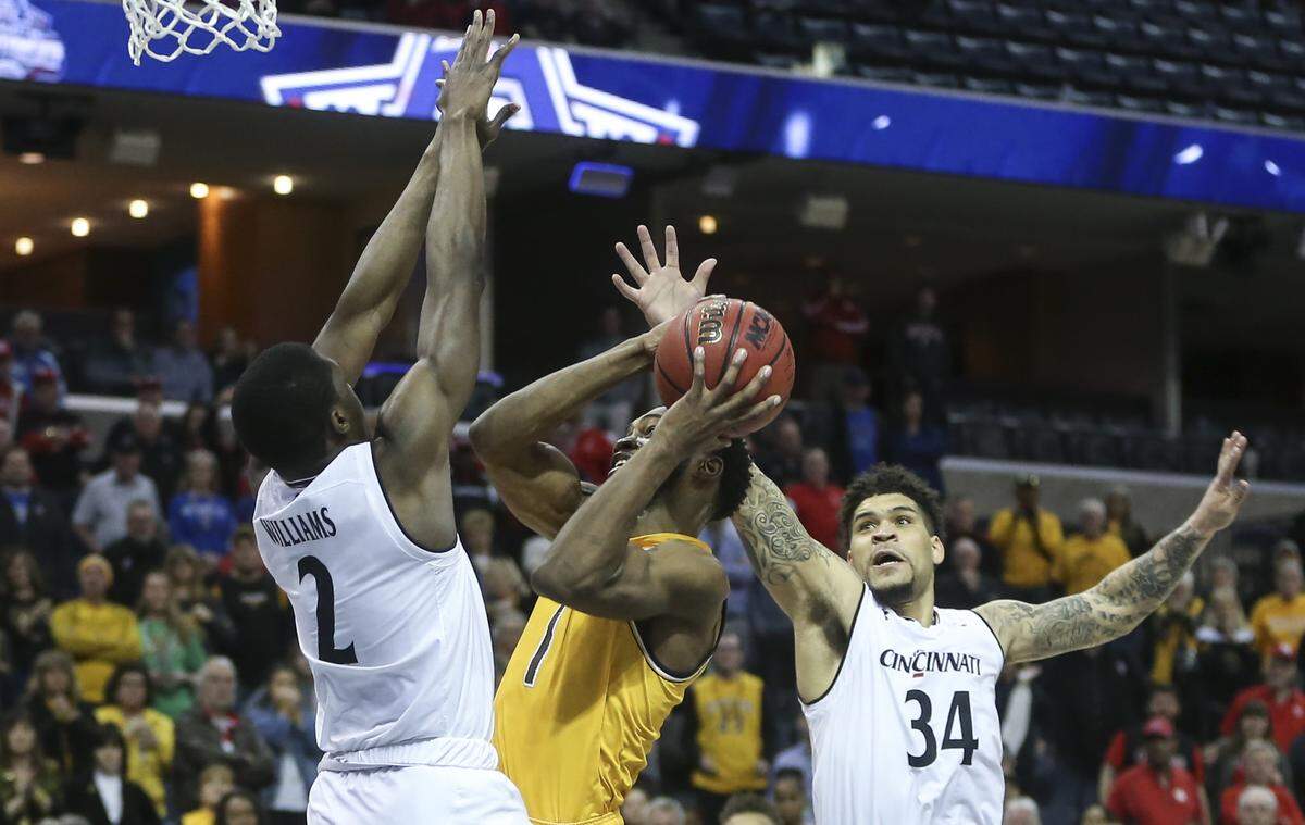 Wichita State forward Markis McDuffie drives to the basket against Cincinnati guard Keith Williams, left, and guard Jarron Cumberland to try and tie the game late in the second half of their American Athletic Conference semifinal game in Memphis on Saturday. McDuffie’s shot fell short and Cincinnati went on to win the game.