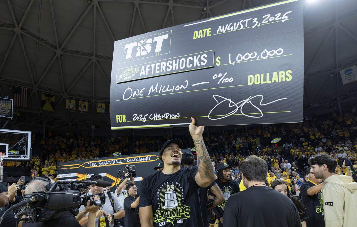 Marcus Santos Silva holds up a giant check after the Aftershocks beat Eberlein Drive to win the million dollar TBT championship on Sunday at Koch Arena.