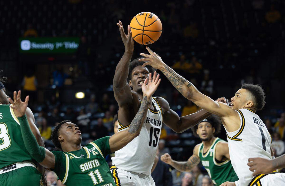 Wichita State’s Quincy Ballard, middle, and Xavier Bell tries try and grab a rebound against South Florida’s CJ Brown during the second half of their game on Monday night at Koch Arena. 