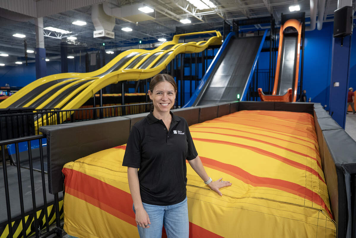 Sky Zone of Wichita co-owner Ashley Youngdale next to a slide that catapults the rider onto a giant cushion.
