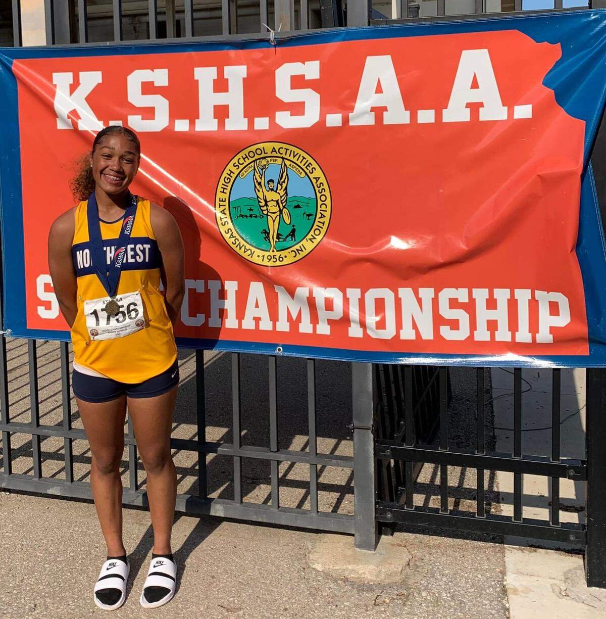 Northwest’s Adryanna Shelby celebrates with her gold medal at the Kansas high school state track and field meet.