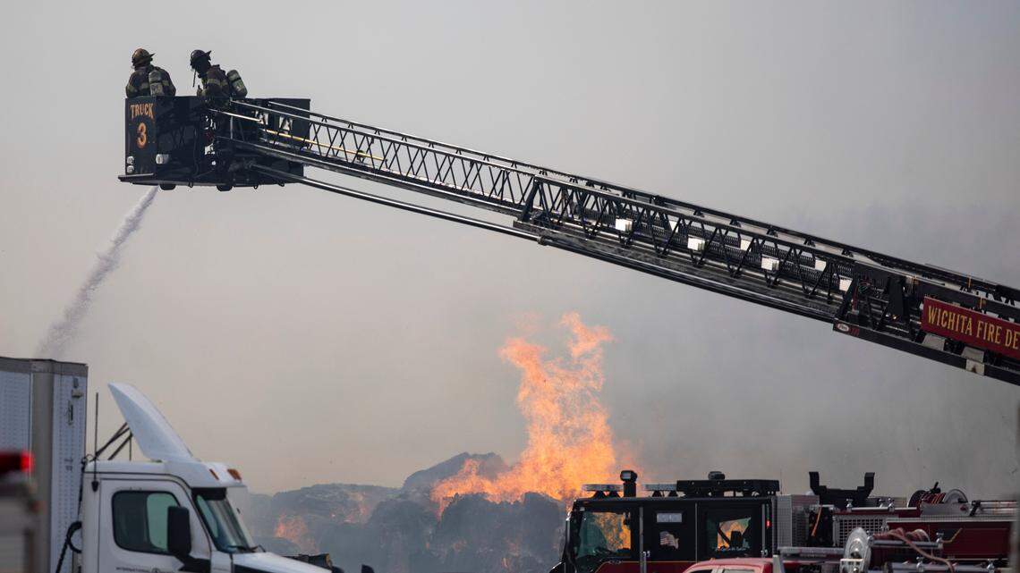Firefighters battle a three-alarm fire at a recycling facility in southwest Wichita on Monday.