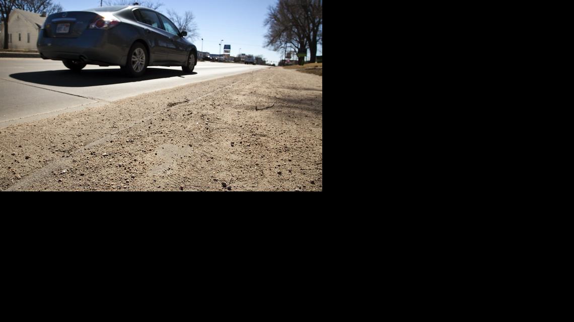 Sand covers the sidewalk on Seneca north of Douglas. City street crews dumped 7,000 tons of sand over 1,500 lane-miles of ice-covered emergency routes in a snowstorm in early February, after snow removal efforts failed during the winter’s first major storm. (March 13, 2014)

