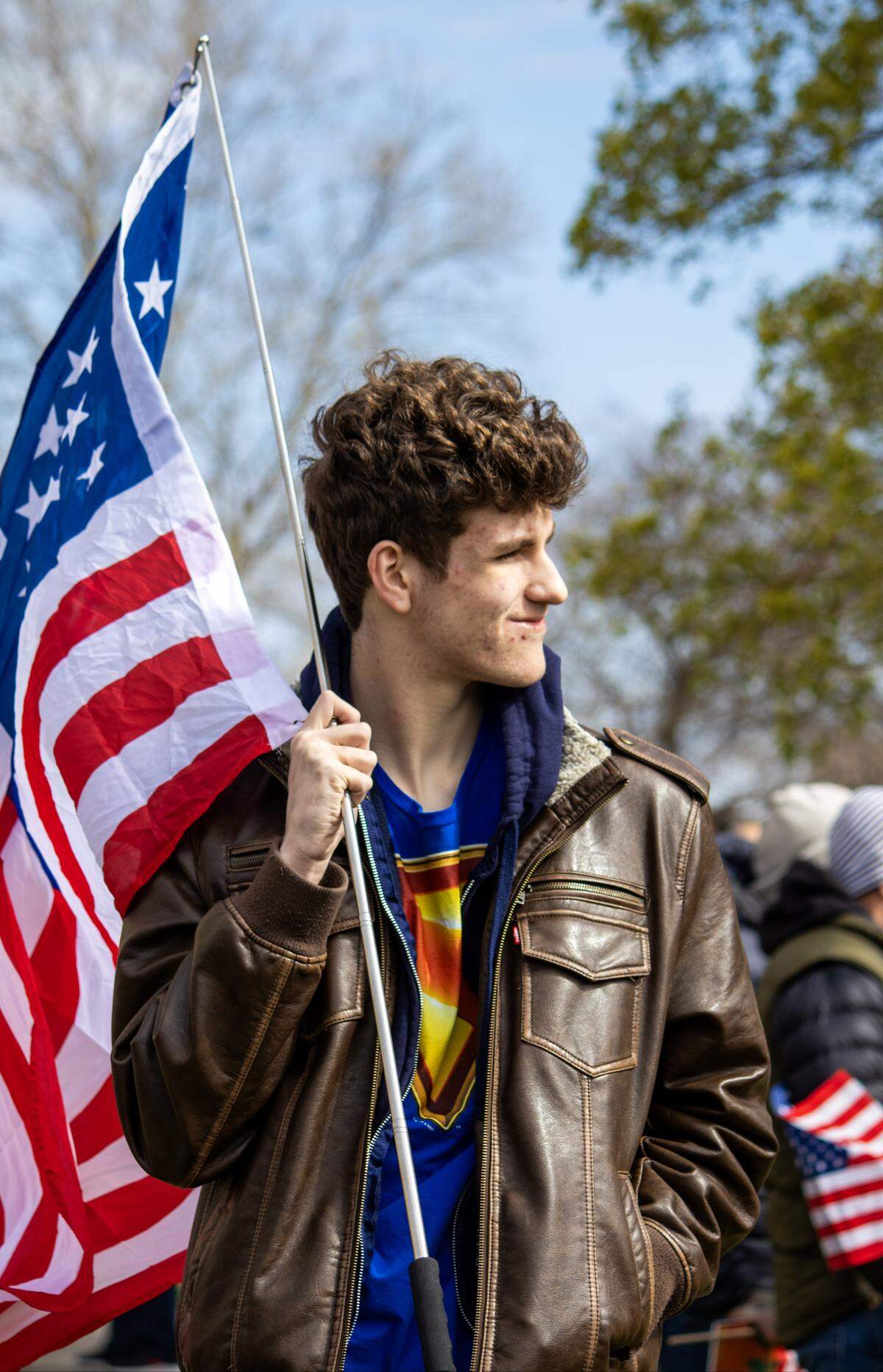 17-year-old Jackson Rukes holds an American flag while protesting outside the Historic County Courthouse on Saturday afternoon. Rukes said he attended the previous two No Kings protests because “I just don’t like bullies.”