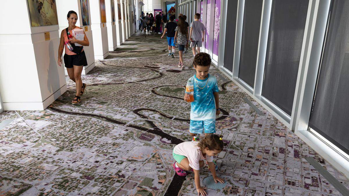 Juliette Jacks and her brother Beau check out the depiction of Century II on Wednesday on a new “Magic Carpet” that lines the bridge in Exploration Place.
