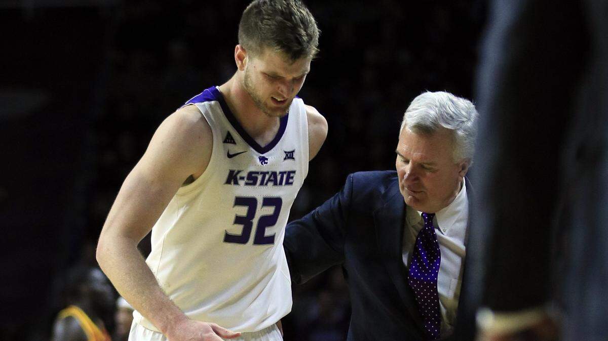 Kansas State head coach Bruce Weber, right, helps forward Dean Wade (32) to the bench after an injury during the second half of an NCAA college basketball game against Iowa State in Manhattan, Kan., Saturday, Feb. 16, 2019. Wade did not return to the game. (AP Photo/Orlin Wagner)