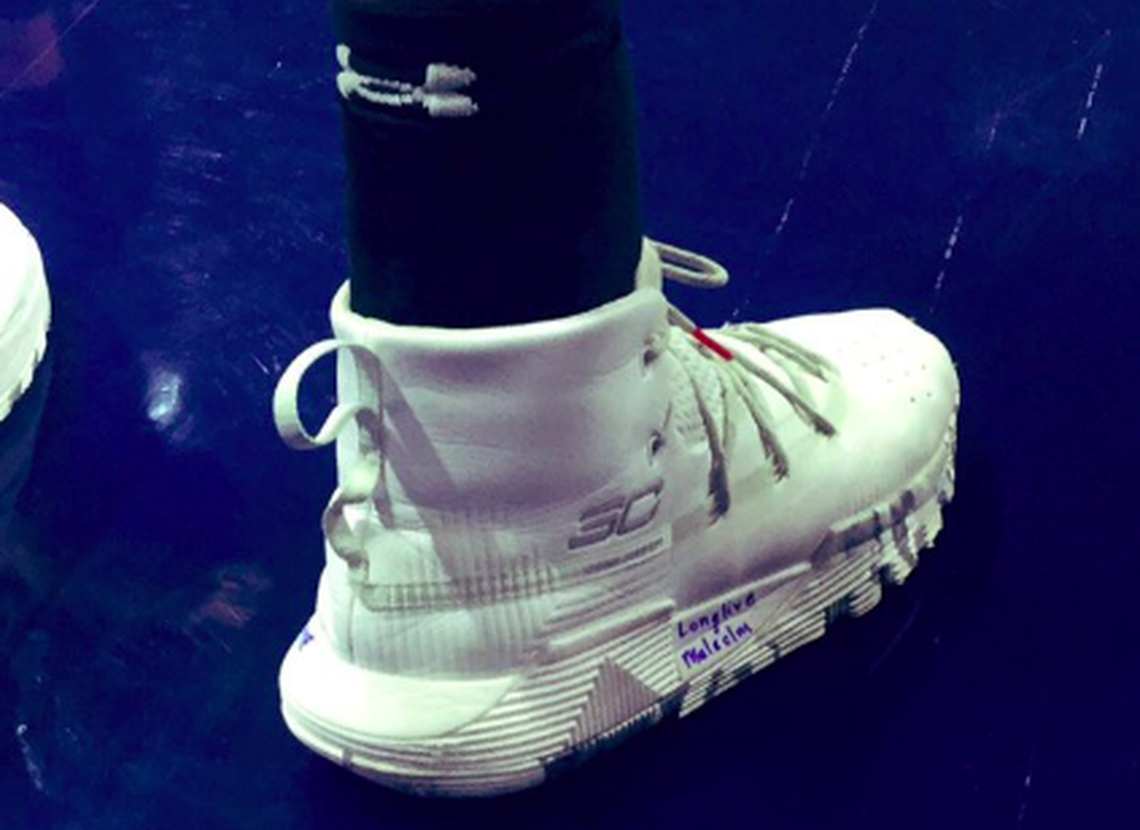 Wichita State freshman Dexter Dennis writes “Long Live Malcolm” on his playing shoes to honor a former teammate who was shot and killed.