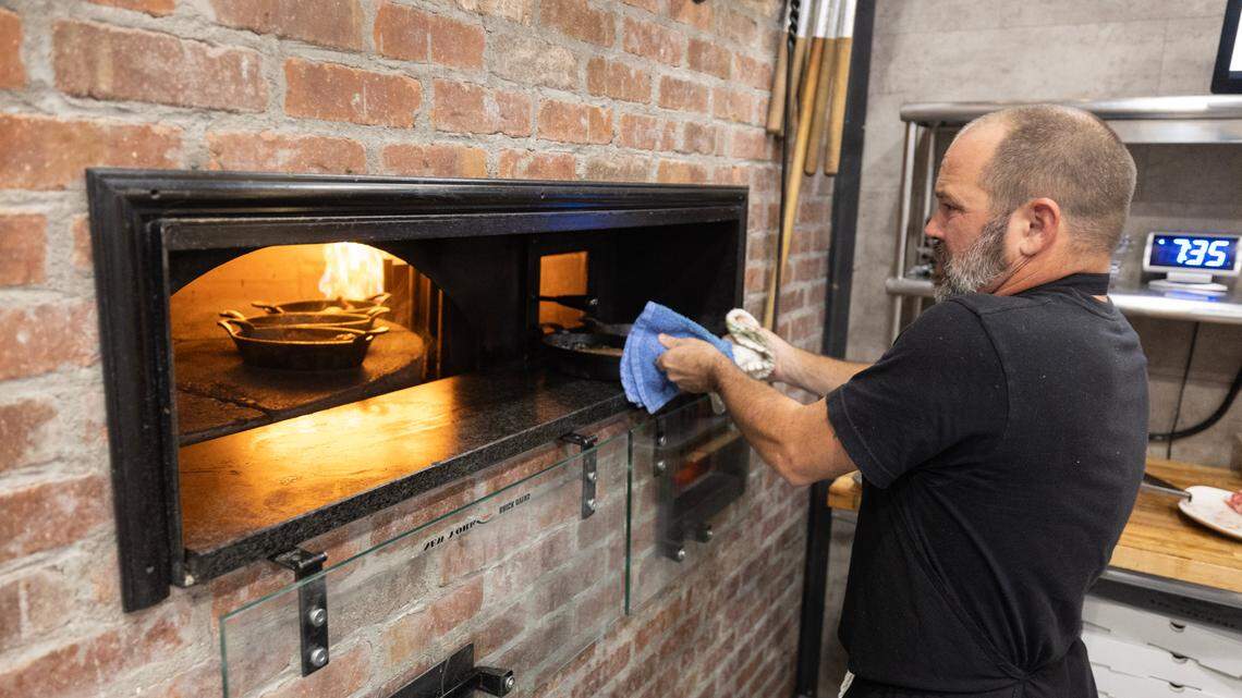 Dustin Presley prepares ribeye steaks to order on the third Monday of every month at The Hub, a popular brick oven pizza restaurant in Moundridge.