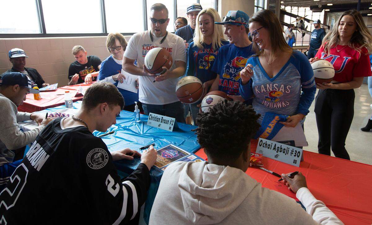 University of Kansas basketball stars Christian Braun, left, and Ochai Agbaji, right, sign autographs at East High School. Wichita was the first stop of the state-wide barnstorming tour for the Kansas menÕs basketball national championship team. Because of recent NCAA policy changes, all 18 players on the 2021-22 KU team Ñ not just the graduating seniors Ñ were eligible to participate on the tour. (April 23, 2022)